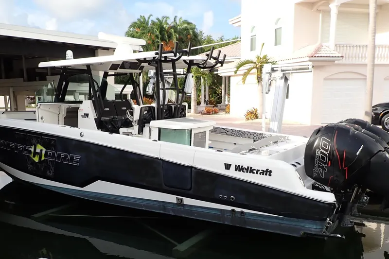  Yacht Photos Pics 2019 Wellcraft 352 Fisherman boat docked near a waterfront home.