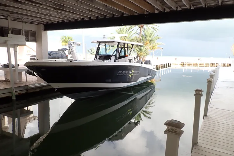  Yacht Photos Pics 2019 Wellcraft 352 Fisherman boat docked in a covered marina, reflecting on calm water.