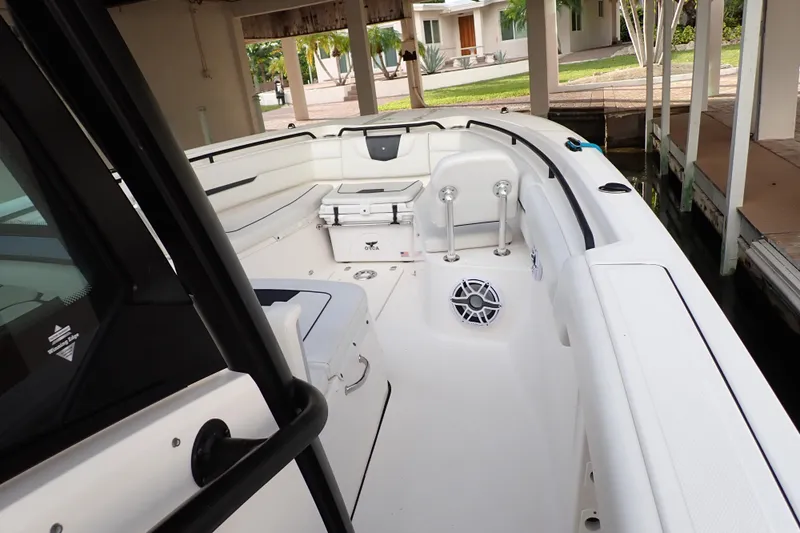  Yacht Photos Pics 2019 Wellcraft 352 Fisherman boat interior with seating and storage under a covered dock.