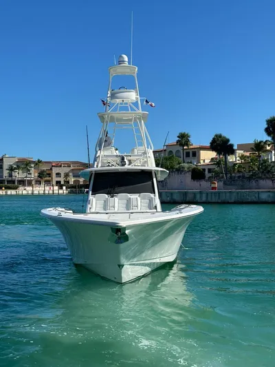 Scout 530 Lxf Yacht Photos Pics 2021 Scout 530 LXF boat on clear blue water near waterfront homes.