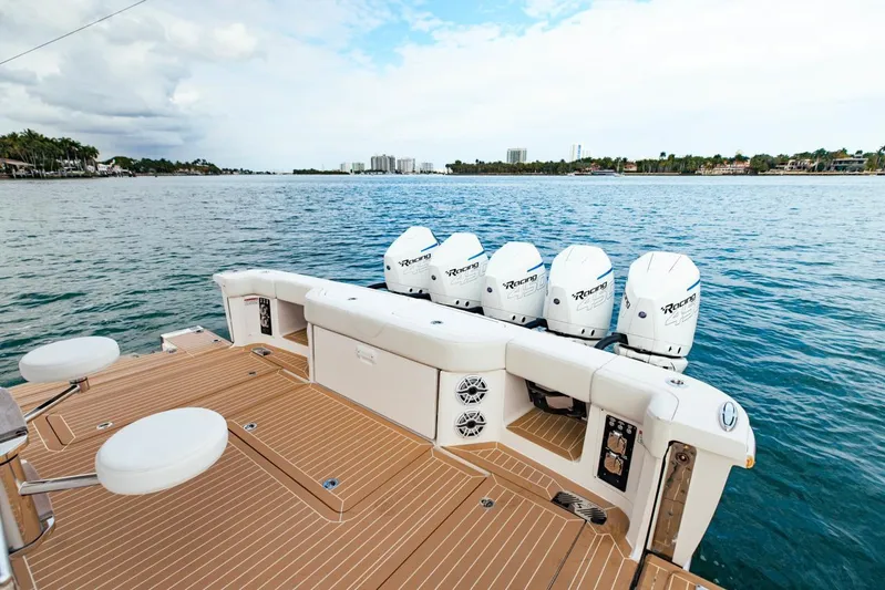 Scout 530 Lxf Yacht Photos Pics 2021 Scout 530 LXF boat with four powerful outboard engines on a serene waterway.