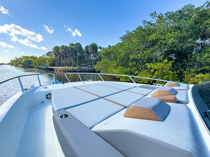  Yacht Photos Pics 2024 Beneteau Flyer 10 boat with spacious deck, cruising near lush greenery and calm waters.