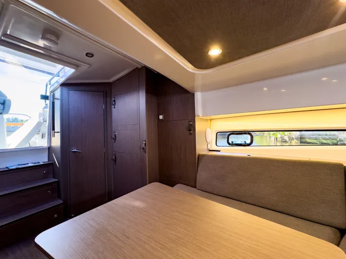  Yacht Photos Pics 2024 Beneteau Flyer 10 cabin interior with modern seating and wooden finishes.