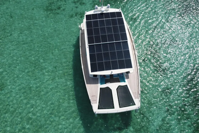 Firefly Yacht Photos Pics Aerial view of 2018 Serenity 64 yacht with solar panels on turquoise water.