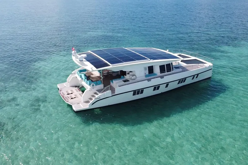 Firefly Yacht Photos Pics Solar-powered Serenity 64 yacht from 2018 on clear turquoise waters.