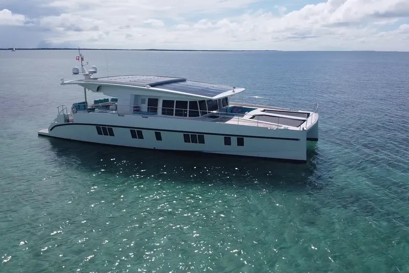 Firefly Yacht Photos Pics Luxurious 2018 Serenity 64 yacht cruising on clear blue ocean waters.