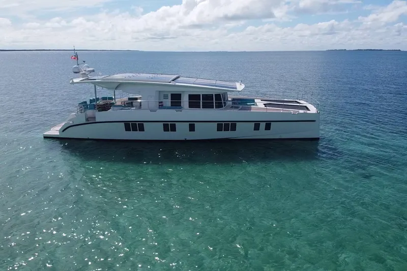 Firefly Yacht Photos Pics Luxurious 2018 Serenity 64 yacht cruising on clear turquoise waters under a sunny sky.