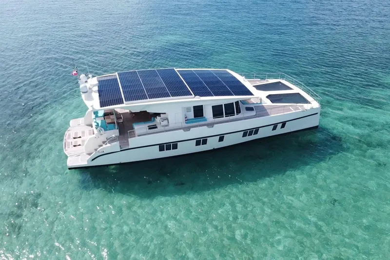 Firefly Yacht Photos Pics Solar-powered Serenity 64 yacht from 2018 on clear turquoise waters.