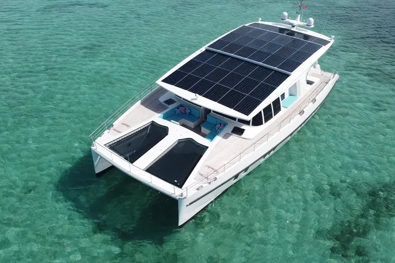 Firefly Yacht Photos Pics Solar-powered Serenity 64 yacht from 2018 on clear turquoise waters.