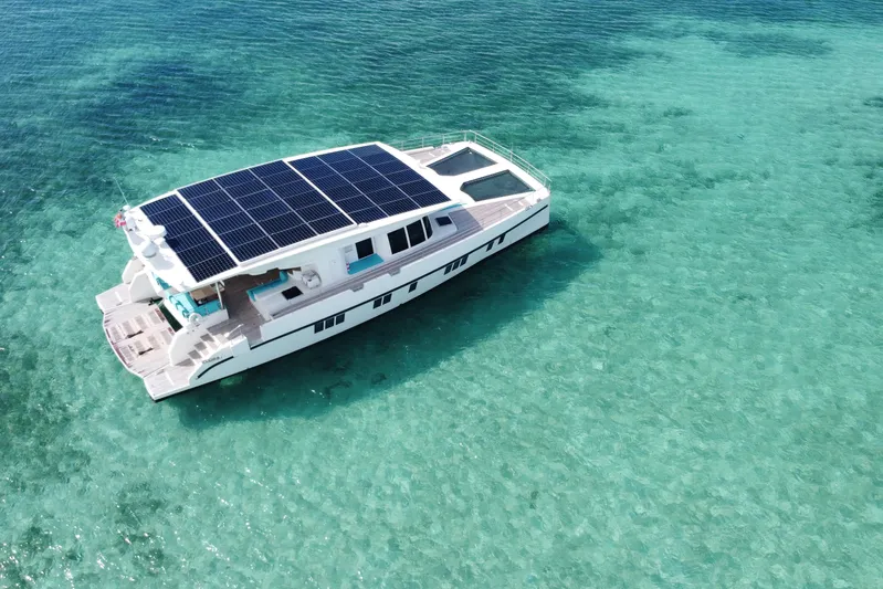 Firefly Yacht Photos Pics Solar-powered Serenity 64 yacht from 2018 on clear turquoise waters.