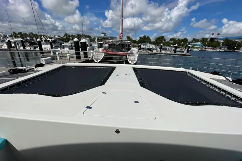 Firefly Yacht Photos Pics Serenity 64 yacht docked at marina, showcasing spacious deck and clear blue sky.