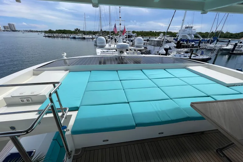 Firefly Yacht Photos Pics Luxurious Serenity 64 yacht deck with turquoise cushions, docked at a marina, 2018 model.