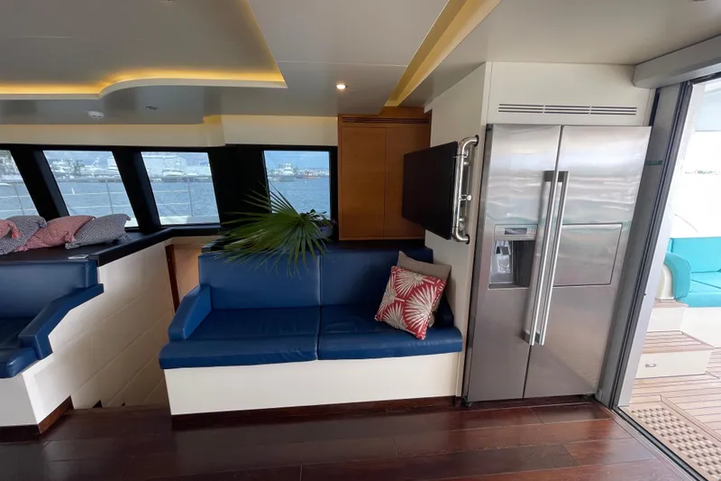 Firefly Yacht Photos Pics Luxurious interior of 2018 Serenity 64 yacht with modern seating and stainless steel refrigerator.