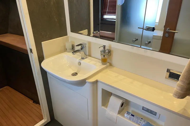 Firefly Yacht Photos Pics Modern bathroom sink area in a 2018 Serenity 64 yacht, featuring sleek fixtures and storage.