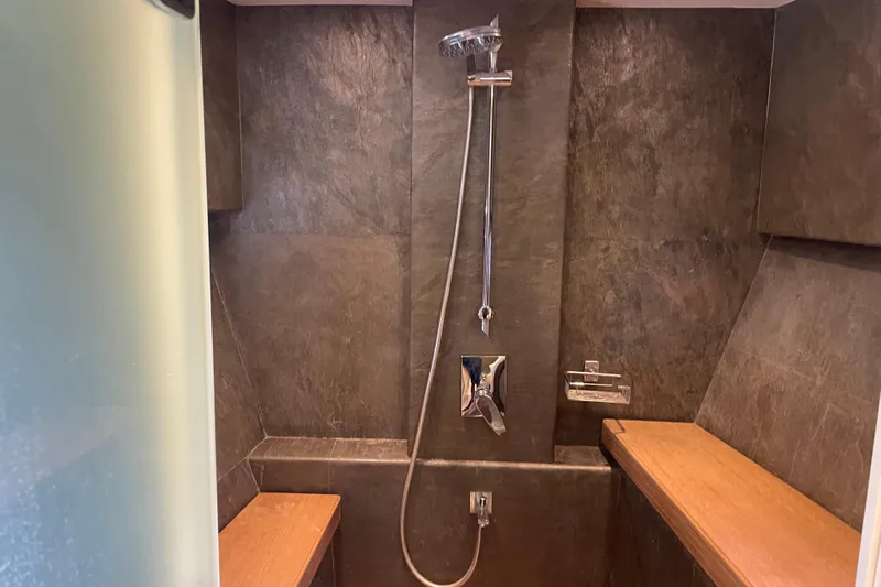 Firefly Yacht Photos Pics Luxurious shower area in 2018 Serenity 64 yacht with modern fixtures and wooden accents.