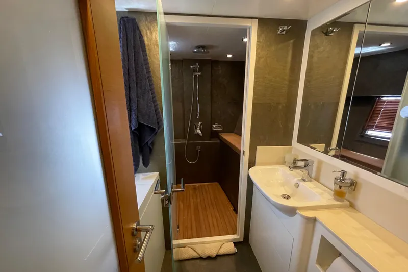 Firefly Yacht Photos Pics Luxurious yacht bathroom with modern shower, sink, and wooden accents, Serenity 64, 2018 model.