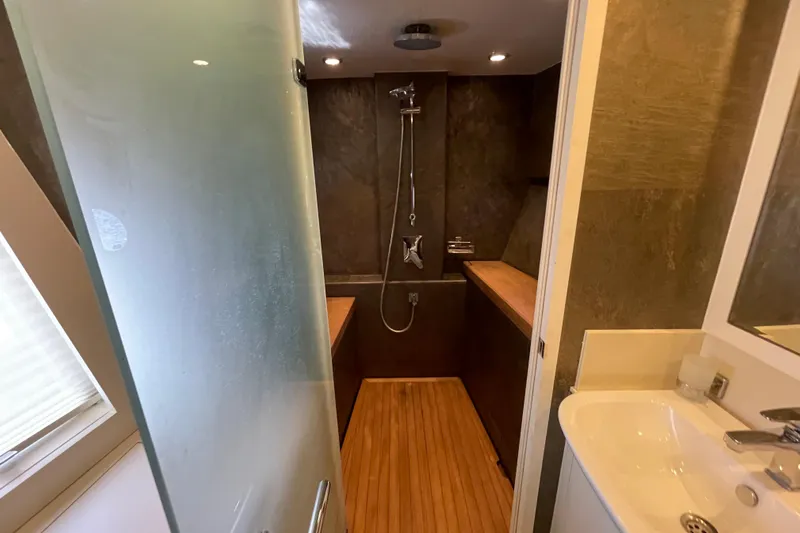 Firefly Yacht Photos Pics Modern bathroom in 2018 Serenity 64 yacht with glass door and wooden accents.