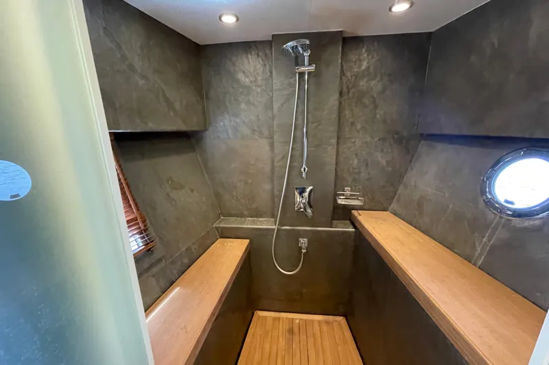 Firefly Yacht Photos Pics Luxurious shower in 2018 Serenity 64 yacht with modern fixtures and wooden accents.