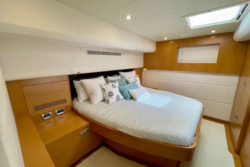 Firefly Yacht Photos Pics Luxurious bedroom interior on 2018 Serenity 64 yacht, featuring elegant wood finishes and plush bedding.