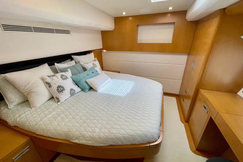 Firefly Yacht Photos Pics Luxurious bedroom interior on 2018 Serenity 64 yacht, featuring elegant bedding and wooden accents.
