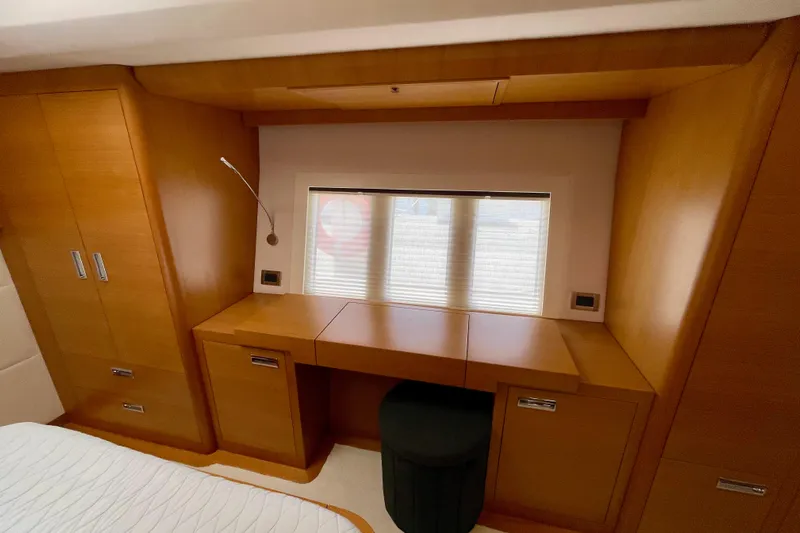 Firefly Yacht Photos Pics Luxurious wooden interior of a 2018 Serenity 64 yacht cabin with desk and storage.