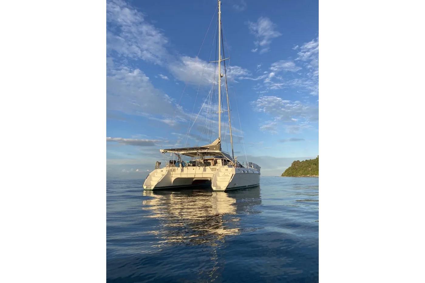 Sailing catamaran Privilege 482, 1992 model, on calm ocean waters under a blue sky.
