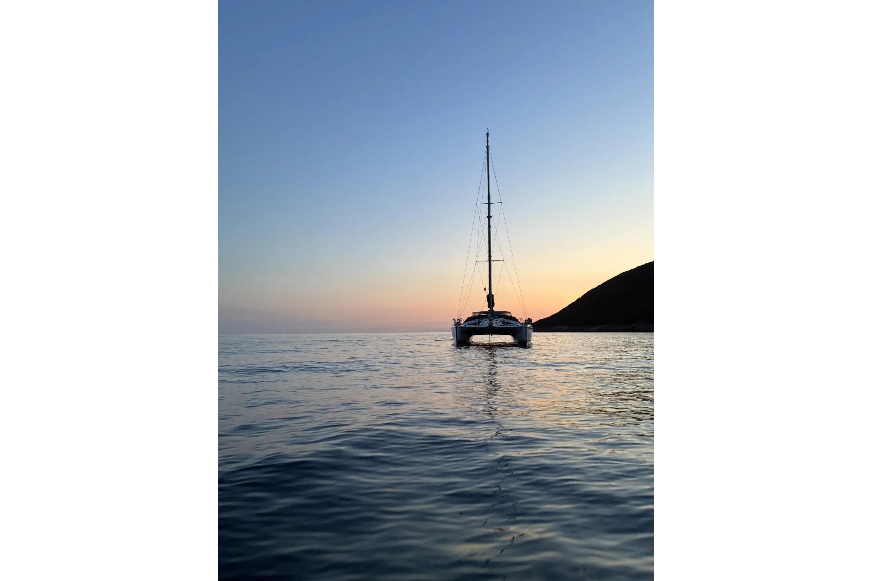 Sailing catamaran Privilege 482 at sunset, 1992 model, on calm sea.