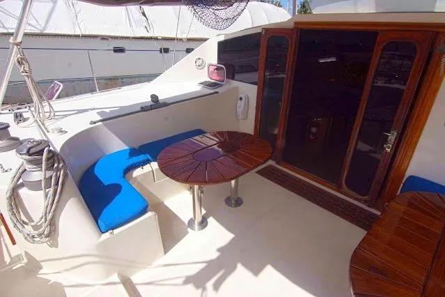 Deck of 1992 Privilege 482 yacht with blue seating and wooden tables.