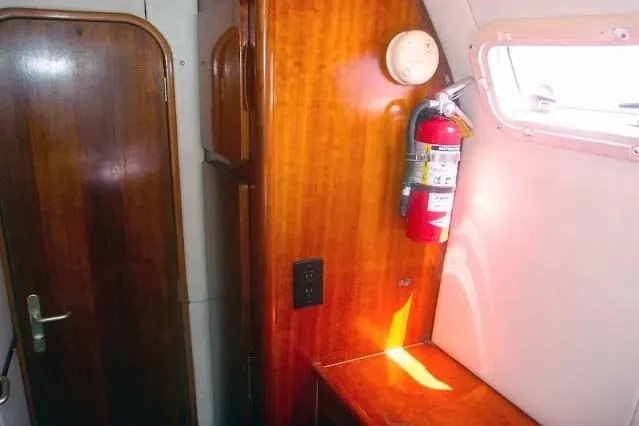 Scout Yacht Photos Pics Interior of 1992 Privilege 482 yacht with wooden paneling and fire extinguisher.