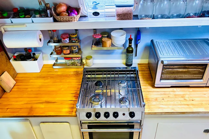 Scout Yacht Photos Pics Kitchen with stove, toaster oven, spices, and wooden countertop in Privilege 482, 1992 model.