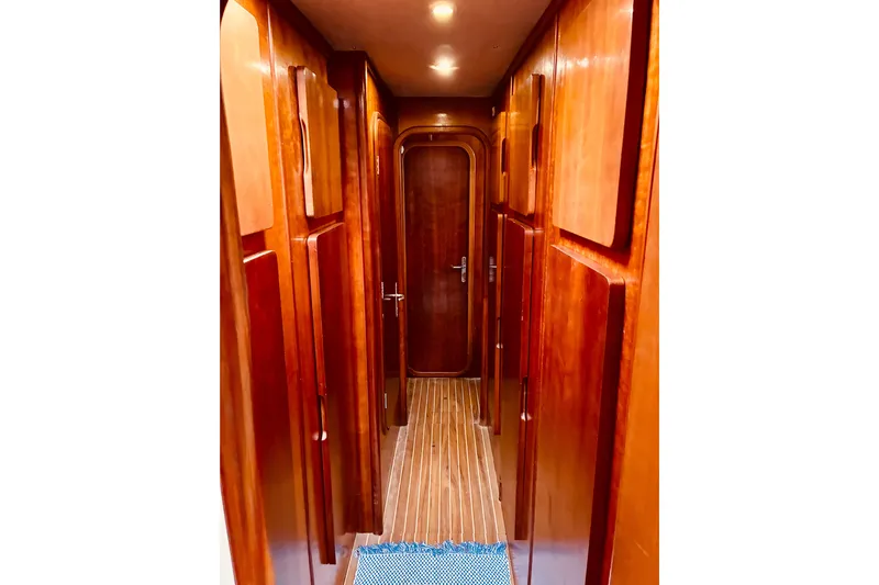 Scout Yacht Photos Pics Narrow wooden hallway inside 1992 Privilege 482 yacht, featuring sleek cabinetry and lighting.