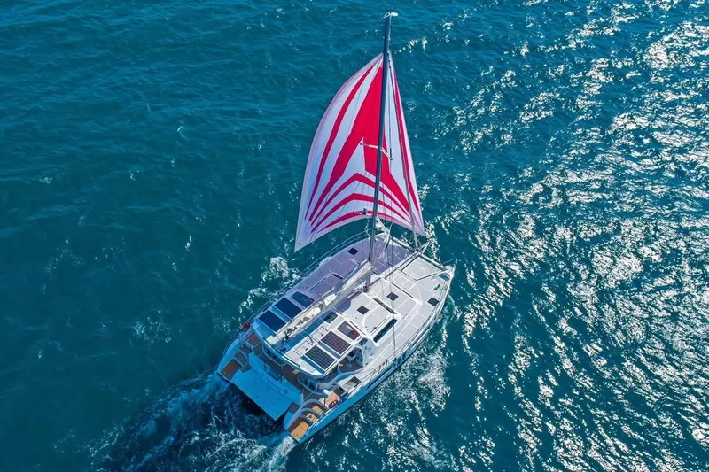 Lost Abbey Yacht Photos Pics 2021 Royal Cape Catamarans Majestic sailing on open blue sea with vibrant red and white sail.