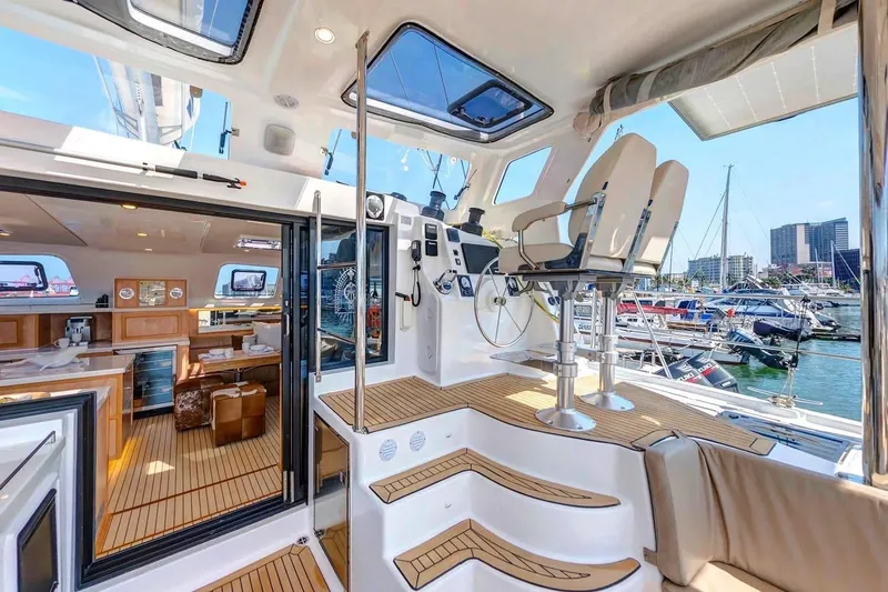 Lost Abbey Yacht Photos Pics Luxurious 2021 Royal Cape Catamarans Majestic interior with helm, seating, and marina view.