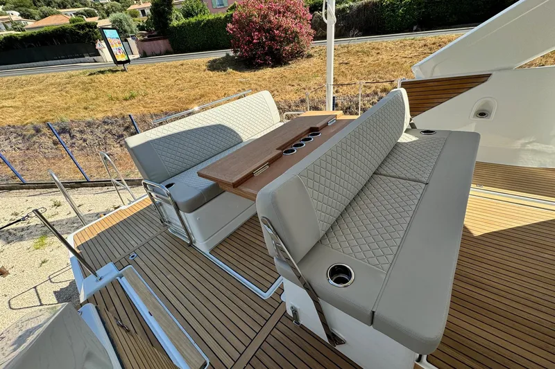  Yacht Photos Pics Luxury seating area on 2026 Jeanneau DB/37 IB yacht with elegant wood and quilted upholstery.