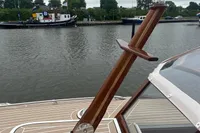 2022 STATEMENT MARINE PTS 26 boat with wooden details on a calm waterway.