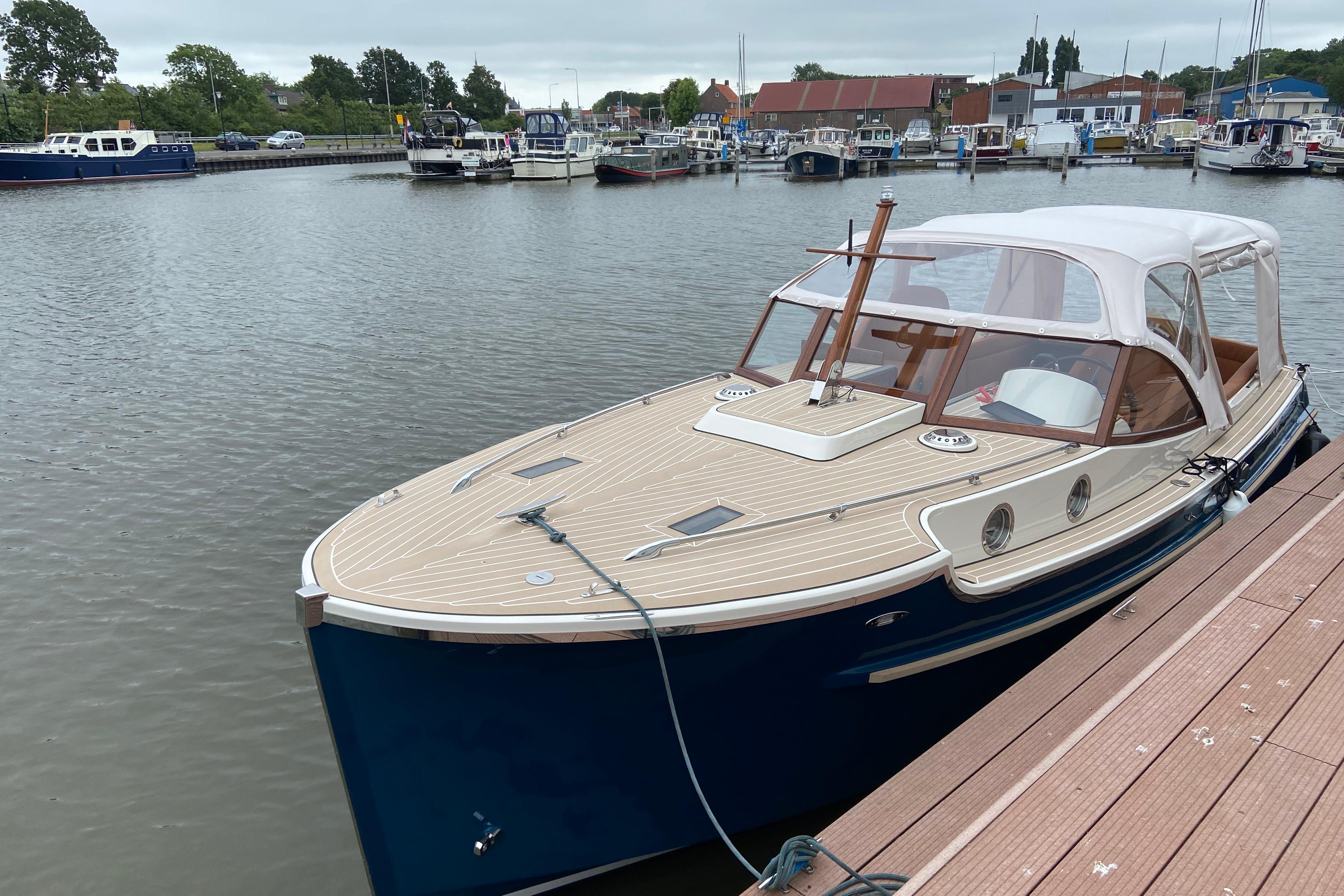 2022 STATEMENT MARINE PTS 26 boat docked in a marina, featuring elegant design and canopy.