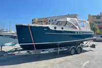 2022 STATEMENT MARINE PTS 26 boat on trailer at marina, sunny day.