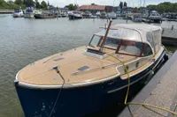 2022 STATEMENT MARINE PTS 26 boat docked in a marina, featuring a sleek wooden deck.