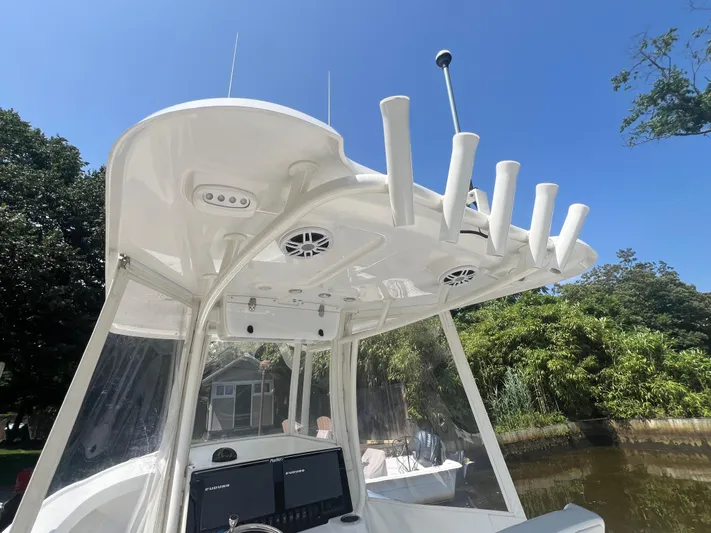  Yacht Photos Pics 2023 Parker 2801 Center Console boat with rod holders and electronics, docked near lush greenery.