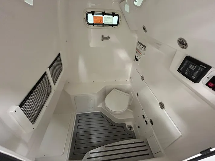  Yacht Photos Pics 2024 Everglades 285 Center Console boat interior cabin with toilet and storage compartments.