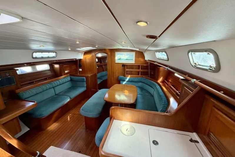 Eda Yacht Photos Pics Interior of 2000 Beneteau Oceanis 461 sailboat with wood finish and blue seating.
