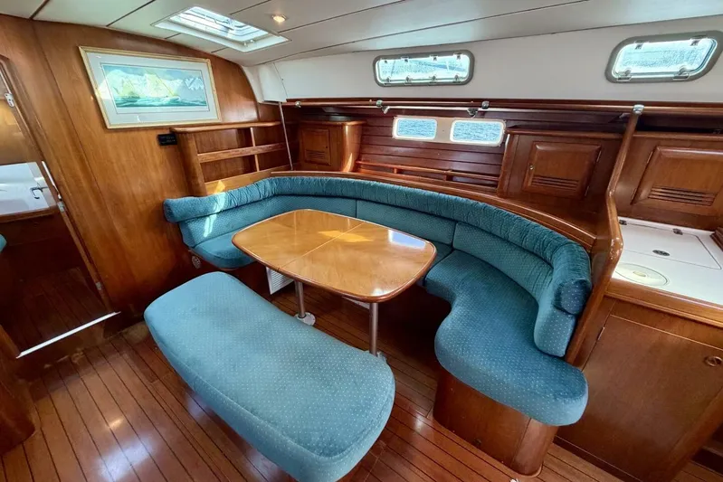 Eda Yacht Photos Pics Luxurious interior of 2000 Beneteau Oceanis 461 yacht with elegant wood and blue seating.