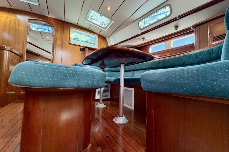 Eda Yacht Photos Pics Interior of 2000 Beneteau Oceanis 461 yacht with wooden flooring and blue cushioned seating.