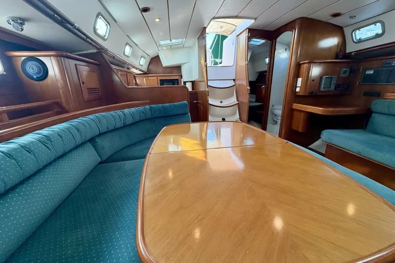 Eda Yacht Photos Pics Luxurious interior of 2000 Beneteau Oceanis 461 sailboat with wood finish and seating area.