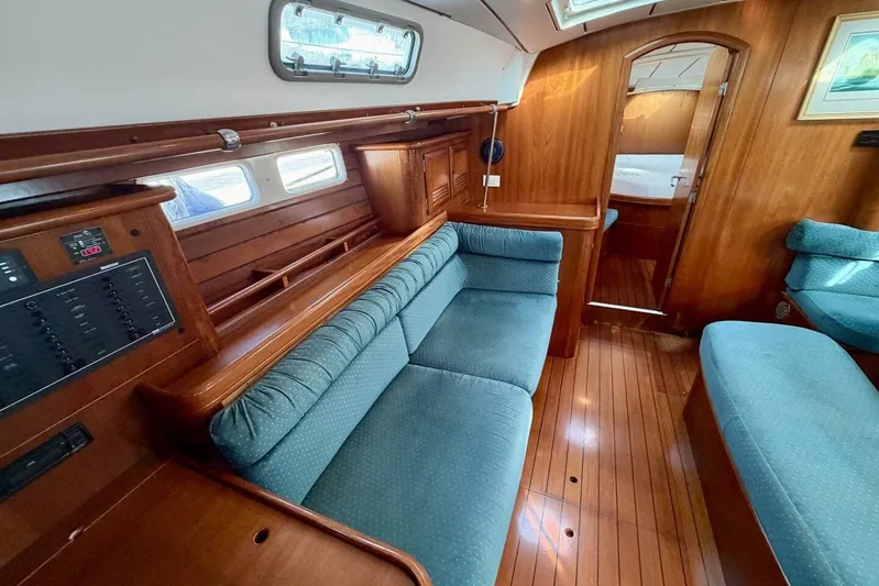 Eda Yacht Photos Pics Interior of 2000 Beneteau Oceanis 461 yacht with blue seating and wooden finishes.