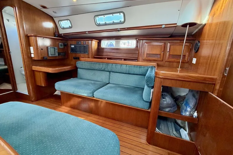 Eda Yacht Photos Pics Interior of 2000 Beneteau Oceanis 461 sailboat with wood finish and green upholstery.