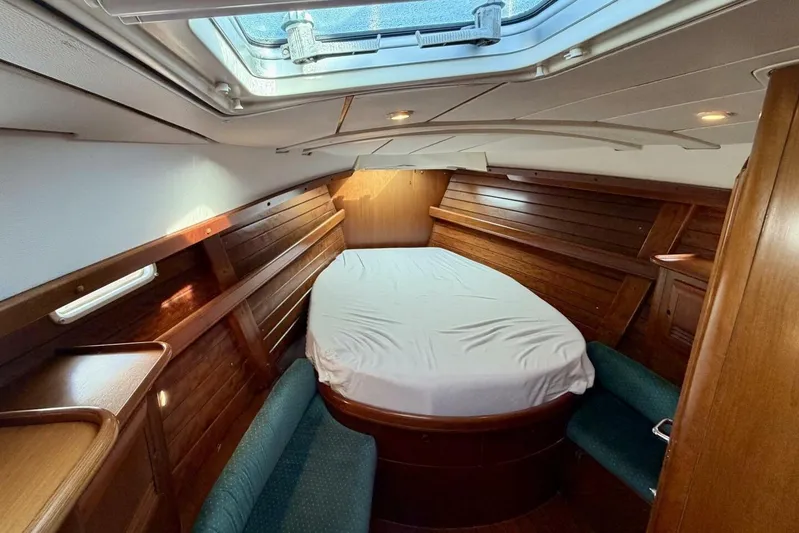 Eda Yacht Photos Pics Luxurious cabin interior of 2000 Beneteau Oceanis 461 sailboat with wood paneling and skylight.