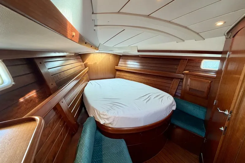 Eda Yacht Photos Pics Cozy cabin interior of 2000 Beneteau Oceanis 461 sailboat with wooden paneling and bed.