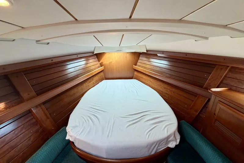 Eda Yacht Photos Pics Cozy cabin interior of 2000 Beneteau Oceanis 461 sailboat with wooden paneling and bed.