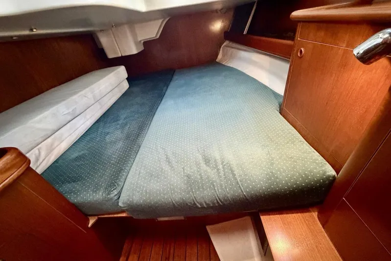 Eda Yacht Photos Pics Cozy cabin interior of 2000 Beneteau Oceanis 461 sailboat with wooden finish and comfortable bedding.